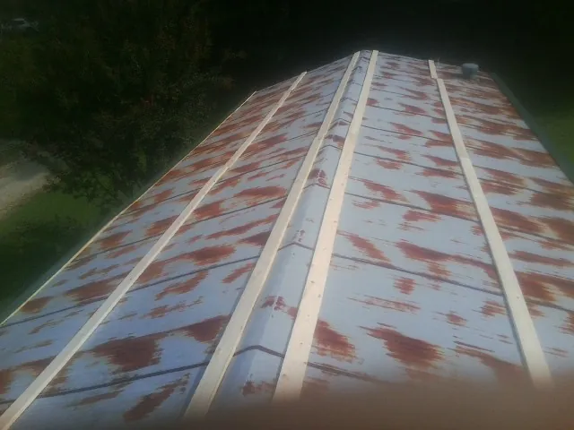 Rusted metal roof panels with new wood purlins before replacement — Storm Damage Roof Repair in Lamar by Roofing Brothers