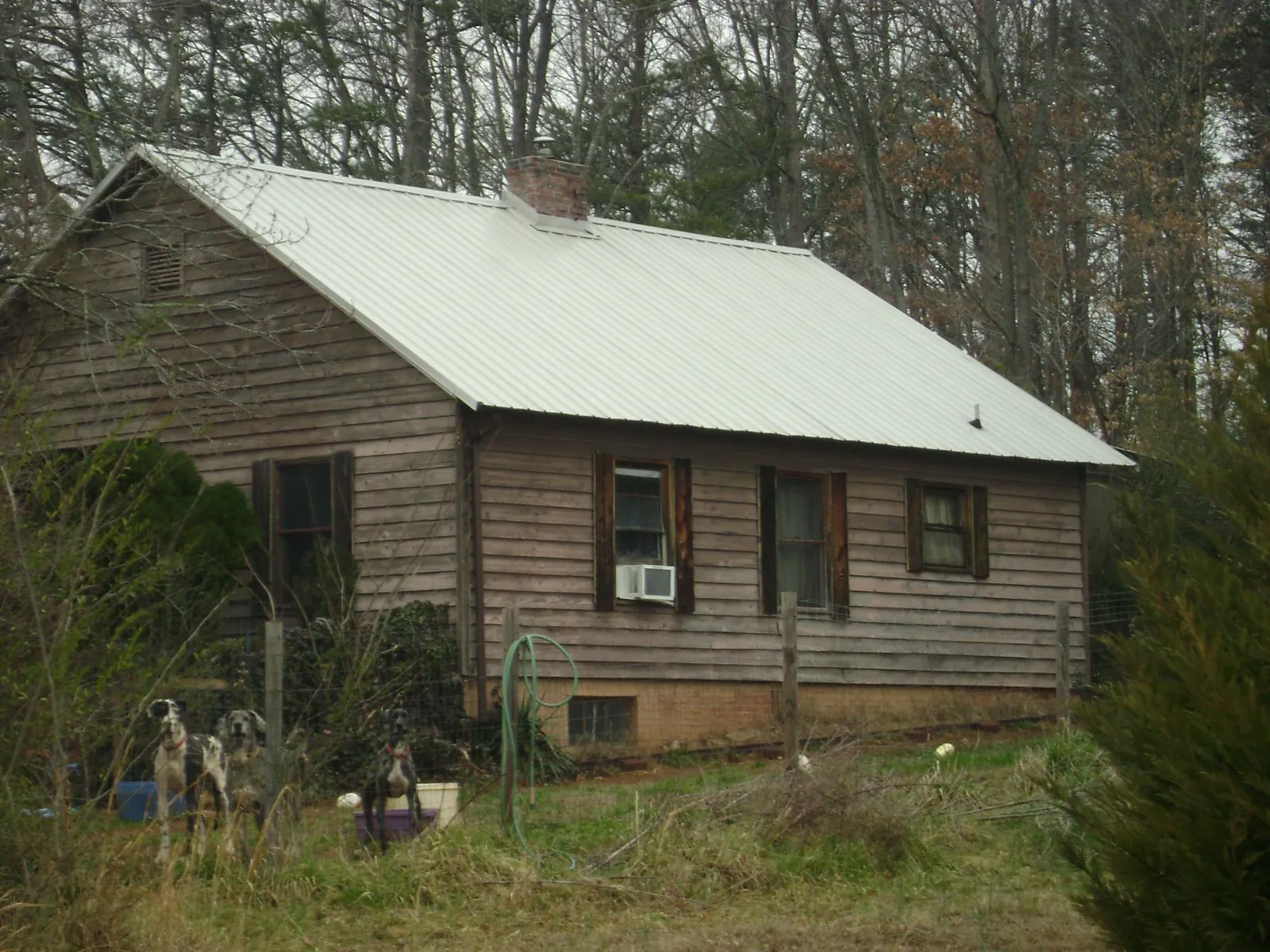 White metal roof on an old wood sided farmhouse, from a Metal Roof Installation job in Lamar